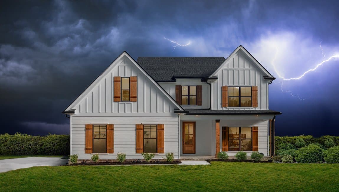Home with white board and batten siding standing up to a storm with lightning in the background