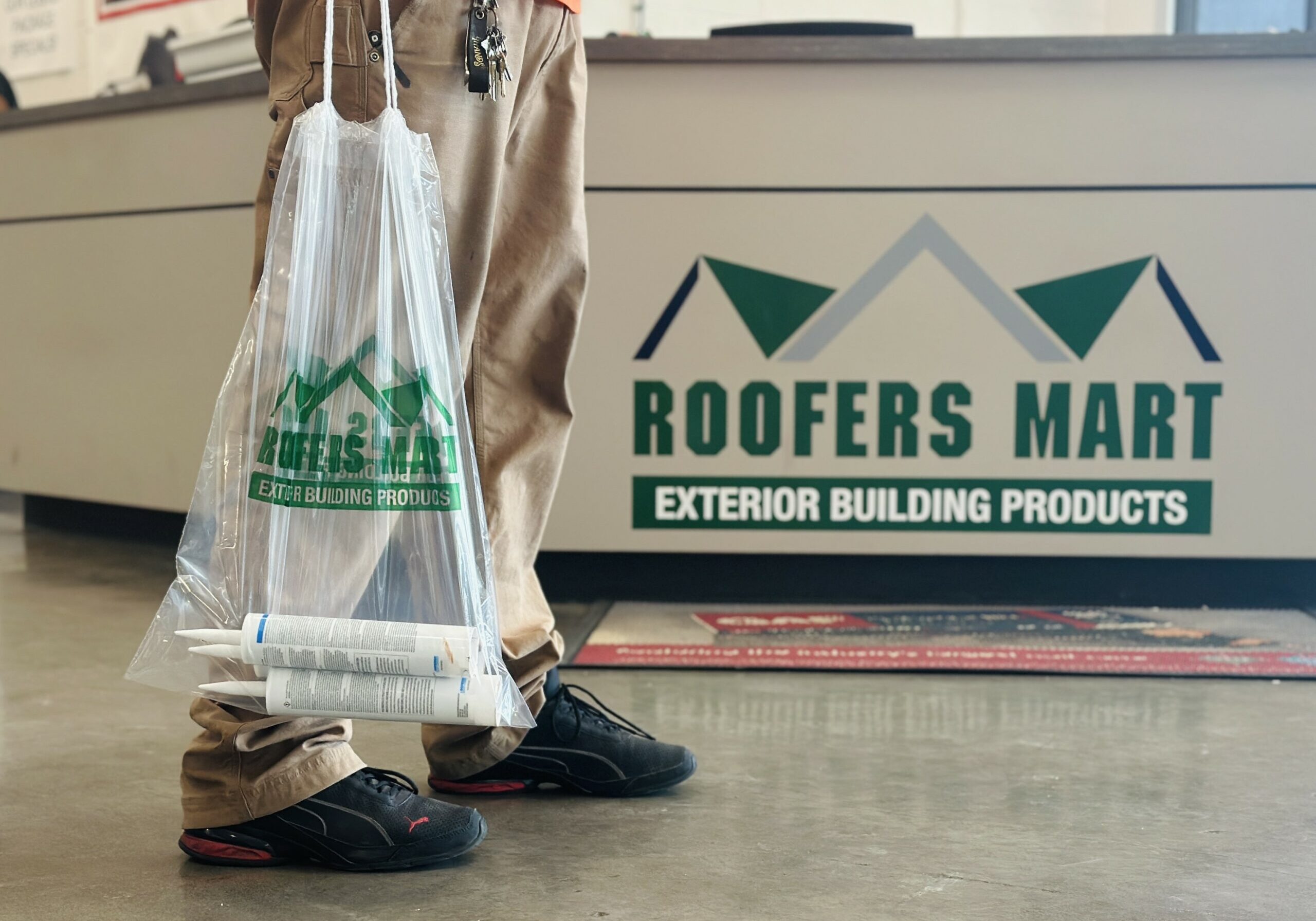 man holding shopping bag in Roofers Mart store